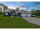 Beautiful single-story home with a well-manicured lawn, arched entryway, and attached three-car garage at 8084 Nightingale Rd, Weeki Wachee, FL 34613