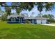 Beautiful single-story home with a well-manicured lawn, arched entryway, and attached three-car garage at 8084 Nightingale Rd, Weeki Wachee, FL 34613