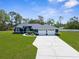 Beautiful single-story home with a well-manicured lawn, arched entryway, and attached three-car garage at 8084 Nightingale Rd, Weeki Wachee, FL 34613