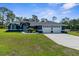 Beautiful single-story home with a well-manicured lawn, arched entryway, and attached three-car garage at 8084 Nightingale Rd, Weeki Wachee, FL 34613