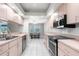 Bright kitchen boasts white tile floors, stainless appliances, and a view to the outdoor dining area at 8084 Nightingale Rd, Weeki Wachee, FL 34613