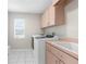 Well-lit laundry room with modern appliances, storage cabinets, and a sink for added convenience at 8084 Nightingale Rd, Weeki Wachee, FL 34613