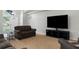 Well-lit living room with a sofa, TV and front door view at 8084 Nightingale Rd, Weeki Wachee, FL 34613