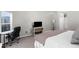 Bright bedroom featuring gray walls, a queen-sized bed, a desk, a shelf and a TV at 8084 Nightingale Rd, Weeki Wachee, FL 34613