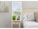 Bright bedroom featuring a night stand with a houseplant, a bed, and a bright window at 8084 Nightingale Rd, Weeki Wachee, FL 34613