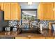 Modern kitchen with stainless steel appliances, mosaic backsplash, and views from the sink window to the living room at 8634 Roble Way, Port Richey, FL 34668