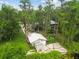 An aerial view of the property's garage and surrounding greenery, including a glimpse of the nearby lake at 8755 Marigold Dr, New Port Richey, FL 34654