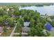 Aerial view of a home with mature trees and landscaping with a view of the lake in the distance at 8755 Marigold Dr, New Port Richey, FL 34654