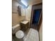 Bathroom featuring a vanity, toilet, sink, mirror and access to another room at 8755 Marigold Dr, New Port Richey, FL 34654