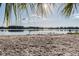 Sandy beach with a view of a lake, trees, and blue sky at 8755 Marigold Dr, New Port Richey, FL 34654