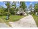 Single-story home featuring a well manicured lawn, a detached garage, and mature trees at 8755 Marigold Dr, New Port Richey, FL 34654