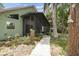 Single-story home featuring a screened in porch, mature landscaping and mature trees at 8755 Marigold Dr, New Port Richey, FL 34654
