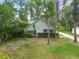 Charming single-story home with green and white exterior and mature trees at 8755 Marigold Dr, New Port Richey, FL 34654