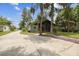Charming home featuring a spacious driveway, mature trees, and a screened front porch at 8755 Marigold Dr, New Port Richey, FL 34654