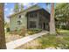 Charming home with screened porch entrance, landscaped walkway, and lush foliage at 8755 Marigold Dr, New Port Richey, FL 34654