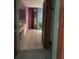 Hallway leading to a bedroom with closet, purple bedroom, and blue room with flower decorations at 8755 Marigold Dr, New Port Richey, FL 34654
