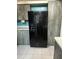 Kitchen showcasing black side-by-side refrigerator and coordinating cabinetry at 8755 Marigold Dr, New Port Richey, FL 34654