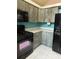 Kitchen featuring gray wood cabinets, black appliances, and a teal backsplash at 8755 Marigold Dr, New Port Richey, FL 34654