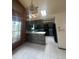 Spacious kitchen with gray wood cabinets, black appliances, breakfast bar, tile floor, and ornate chandelier at 8755 Marigold Dr, New Port Richey, FL 34654