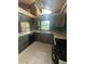 Spacious kitchen with gray wood cabinets, breakfast bar, tile floor, and modern appliances at 8755 Marigold Dr, New Port Richey, FL 34654