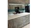 A kitchen with gray wood-look cabinets, a black range, and a breakfast bar at 8755 Marigold Dr, New Port Richey, FL 34654