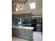 Kitchen with light counter tops, gray wood look cabinets, and a disco ball chandelier at 8755 Marigold Dr, New Port Richey, FL 34654
