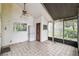 Enclosed screened porch featuring tiled flooring, ceiling fan, and natural light at 8755 Marigold Dr, New Port Richey, FL 34654
