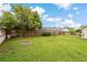 Large, grassy backyard with a fire pit and mature tree at 8850 March Ct, New Port Richey, FL 34655