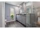 Modern bathroom with gray cabinetry, glass enclosed shower and gray tile at 8850 March Ct, New Port Richey, FL 34655