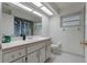 Bathroom featuring a white vanity, tiled floor, and shower-tub combo with a blue shower curtain at 8850 March Ct, New Port Richey, FL 34655