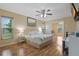 This primary bedroom has hardwood flooring, ensuite bathroom, and a ceiling fan at 8850 March Ct, New Port Richey, FL 34655