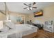 A bedroom with ensuite sitting area, hardwood flooring, ceiling fan, and a television at 8850 March Ct, New Port Richey, FL 34655