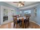 Inviting dining room featuring wood flooring, a bay window, and a modern ceiling fan at 8850 March Ct, New Port Richey, FL 34655