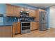 The kitchen features stainless appliances, wooden cabinets, granite counters and a decorative tile backsplash at 8850 March Ct, New Port Richey, FL 34655
