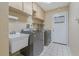 Laundry room featuring a utility sink, washer and dryer, white cabinets, and tiled floors at 8850 March Ct, New Port Richey, FL 34655