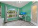 Office space with bright green walls, wood flooring, a large arched window, and a work station at 8850 March Ct, New Port Richey, FL 34655