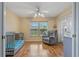 Sitting room with a crib, gray recliner and hardwood flooring at 8850 March Ct, New Port Richey, FL 34655