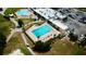 Aerial view of a rectangular pool, palm trees, and lounge chairs at the clubhouse at 9200 Turnberry Ct, New Port Richey, FL 34655