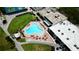 Aerial view of the clubhouse with a unique triangular shaped pool and lounge chairs at 9200 Turnberry Ct, New Port Richey, FL 34655