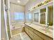 Bright bathroom with soaking tub, large vanity, and glass block window for privacy at 9200 Turnberry Ct, New Port Richey, FL 34655