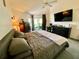 Cozy bedroom features a large window, a ceiling fan, and a desk with a TV at 9200 Turnberry Ct, New Port Richey, FL 34655