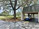 Clubhouse entrance featuring a covered parking spot and a blue golf cart at 9200 Turnberry Ct, New Port Richey, FL 34655