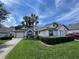 Charming one-story home with manicured lawn, a two-car garage and an American flag at 9200 Turnberry Ct, New Port Richey, FL 34655