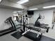 Well-equipped gym featuring a treadmill, elliptical, weight machine, and free weights for a comprehensive workout experience at 9200 Turnberry Ct, New Port Richey, FL 34655