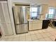 Functional kitchen featuring stainless steel refrigerator, a sink, and white cabinets at 9200 Turnberry Ct, New Port Richey, FL 34655