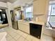 Bright kitchen features stainless steel refrigerator, white cabinets, and black dishwasher at 9200 Turnberry Ct, New Port Richey, FL 34655