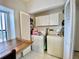 Convenient laundry area with a washer, dryer, extra storage, and a table for folding clothes at 9200 Turnberry Ct, New Port Richey, FL 34655