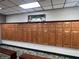 Locker room with wooden lockers and benches at 9200 Turnberry Ct, New Port Richey, FL 34655