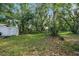 Large grassy backyard with mature trees, ideal for outdoor activities and relaxation at 9401 Bourbon St, New Port Richey, FL 34654
