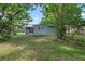 Rear view of the home featuring a screened-in porch and a peaceful yard at 9401 Bourbon St, New Port Richey, FL 34654